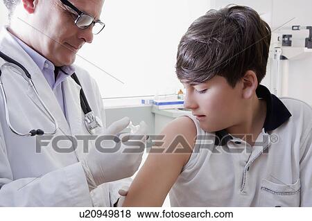 Stock Photo - Teenage boy getting vaccination. Fotosearch