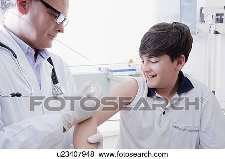 Teenage boy getting vaccination View Large Photo Image Stock Photo - Teenage boy getting vaccination. Fotosearch