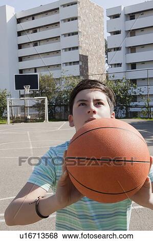 Stock Photo - Teenage boy holding basketball. Fotosearch