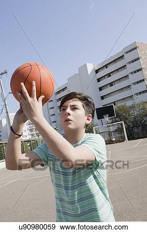 Stock Photo - Teenage boy holding basketball. Fotosearch
