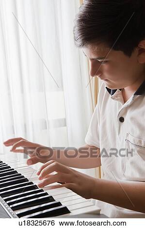 Stock Photograph - Teenage boy playing piano. Fotosearch