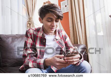 Stock Photo - Teenage boy using smart phone. Fotosearch