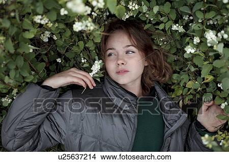 Teenage girl in bush with flowers View Large Photo Image Picture - Teenage girl in bush with flowers. Fotosearch