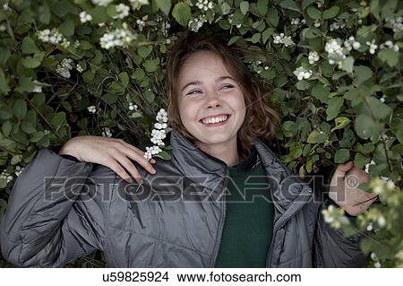 Teenage girl in bush with flowers View Large Photo Image Picture - Teenage girl in bush with flowers. Fotosearch