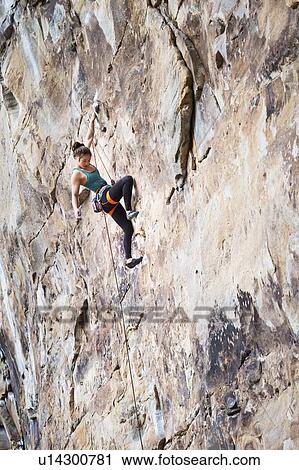 Stock Image - Teenage girl rock climbing. Fotosearch