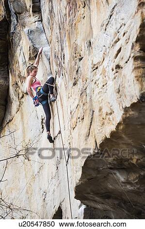 Stock Image - Teenage girl rock climbing. Fotosearch