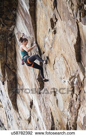 Stock Image - Teenage girl rock climbing. Fotosearch