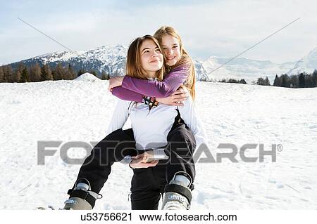 Teenage girl skier getting piggyback from best friend in snow covered landscape, portrait, Tyrol, Styria, Austria View Large Photo Image Stock Image - Teenage girl skier getting piggyback from best friend in snow covered landscape, portrait, Tyrol, Styria, Austria. Fotosearch
