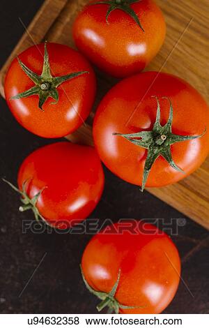 Stock Photo - Tomatoes on wooden cutting board. Fotosearch