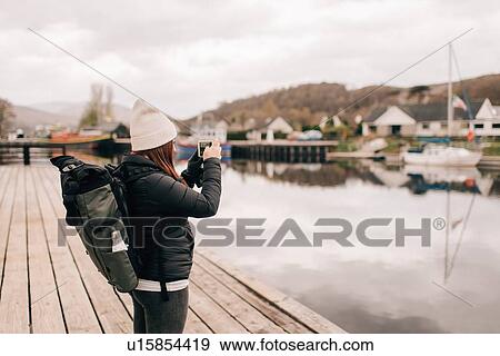 Stock Photo - Trekker photographing Loch Lomond, Trossachs National Park, Canada. Fotosearch