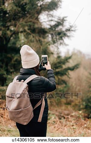 Stock Photography - Trekker taking photo, Trossachs National Park, Canada. Fotosearch