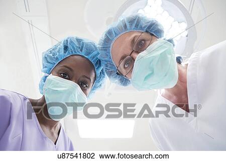 Two female surgeons looking towards camera, personal perspective. View Large Photo Image Stock Image - Two female surgeons looking towards camera, personal perspective.. Fotosearch