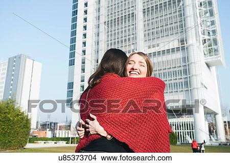 Two young women hugging outside skyscraper, Turin, Piemonte, Italy View Large Photo Image Picture - Two young women hugging outside skyscraper, Turin, Piemonte, Italy. Fotosearch