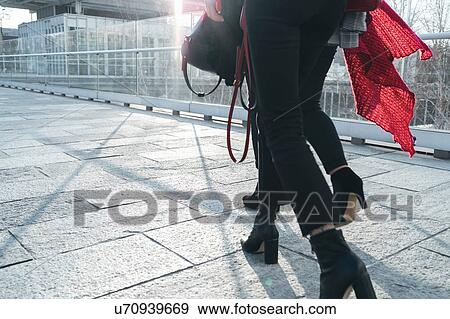 Two young women in ankle boots walking along office path, waist down View Large Photo Image Stock Photo - Two young women in ankle boots walking along office path, waist down. Fotosearch