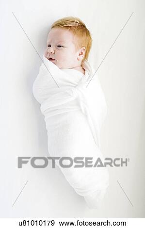 Stock Photo - View directly above swaddled baby boy. Fotosearch