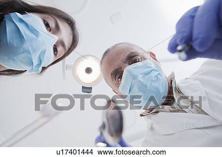 Picture - View directly below dental hygienist and dentist during examination. Fotosearch