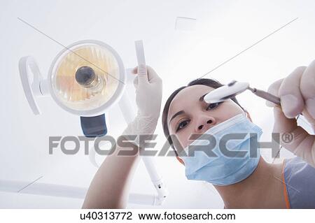 Stock Image - View directly below dental hygienist during examination. Fotosearch
