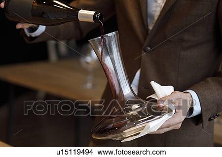 Waiter pouring red wine into decanter View Large Photo Image Picture - Waiter pouring red wine into decanter. Fotosearch