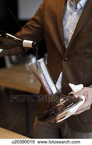Waiter pouring red wine into decanter View Large Photo Image Stock Photo - Waiter pouring red wine into decanter. Fotosearch