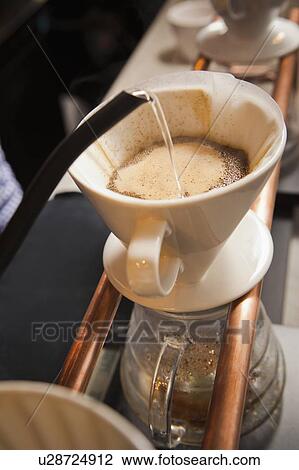 Stock Image - Water being poured into filter coffee. Fotosearch