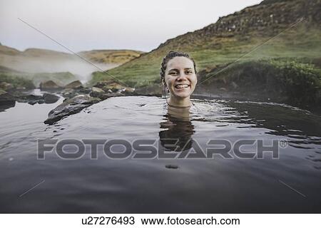 Stock Image - Woman bathing in hotpool in Iceland. Fotosearch
