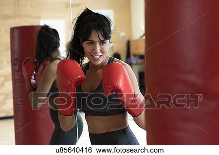Stock Photograph - Woman boxing with punching bag. Fotosearch