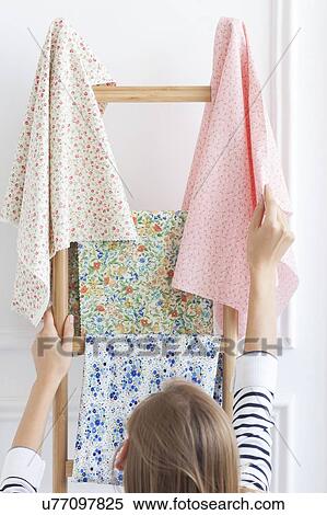Stock Photography - Woman choosing fabric from rack. Fotosearch