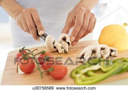 Stock Photo - Woman chopping fresh mushrooms.. Fotosearch