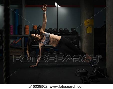 Woman doing side plank in gym View Large Photo Image Stock Image - Woman doing side plank in gym. Fotosearch