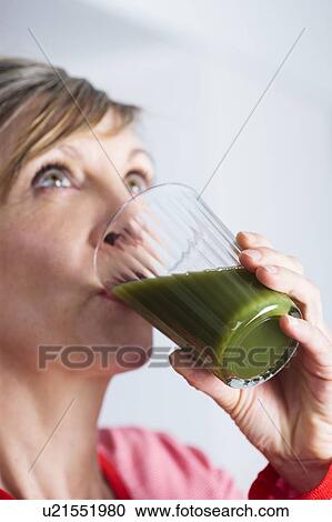 Woman drinking a green juice. View Large Photo Image Stock Image - Woman drinking a green juice.. Fotosearch
