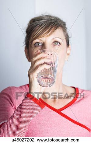 Woman drinking glass of water to hydrate. View Large Photo Image Stock Image - Woman drinking glass of water to hydrate.. Fotosearch