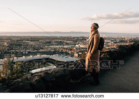 Stock Photo - Woman enjoying view from Calton Hill, Edinburgh, Scotland. Fotosearch