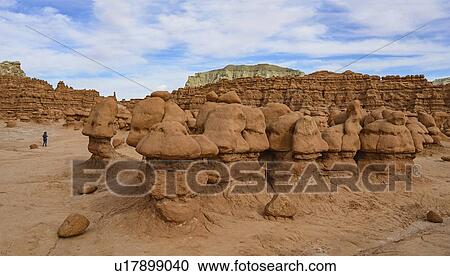 Stock Image - Woman hiking through Goblin Valley State Park in Utah, USA. Fotosearch