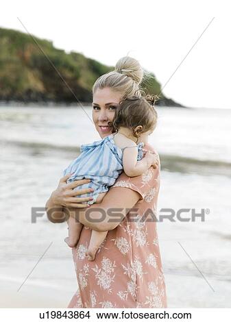 Woman holding baby daughter on beach View Large Photo Image Picture - Woman holding baby daughter on beach. Fotosearch