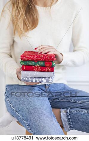 Stock Image - Woman holding Christmas fabrics. Fotosearch