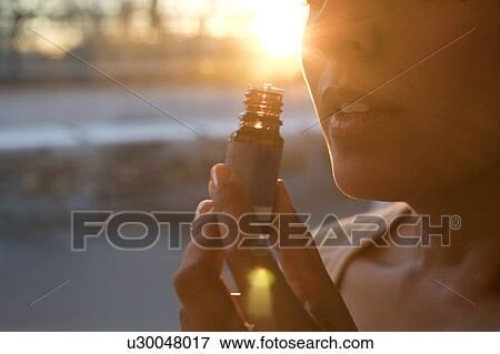 Stock Photo - Woman holding essential oil bottle.. Fotosearch