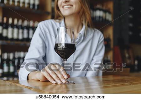 Picture - Woman holding glass of red wine. Fotosearch