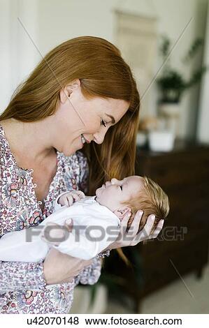 Woman holding her newborn son View Large Photo Image Stock Photo - Woman holding her newborn son. Fotosearch