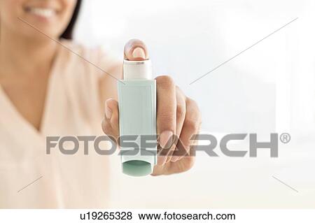 Stock Photo - Woman holding inhaler.. Fotosearch