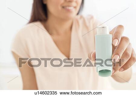Stock Photography - Woman holding inhaler.. Fotosearch