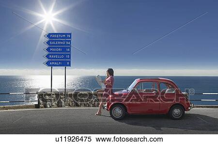 Woman holding map leaning on pink car View Large Photo Image Stock Photography - Woman holding map leaning on pink car. Fotosearch