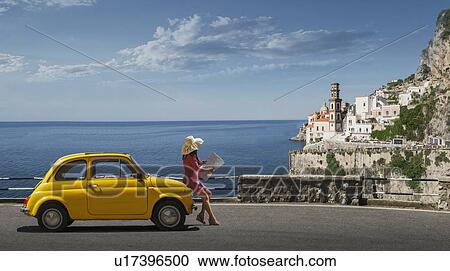 Woman holding map leaning on yellow car in Atrani, Italy View Large Photo Image Stock Image - Woman holding map leaning on yellow car in Atrani, Italy. Fotosearch