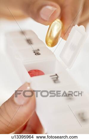 Woman holding pill organiser. View Large Photo Image Picture - Woman holding pill organiser.. Fotosearch