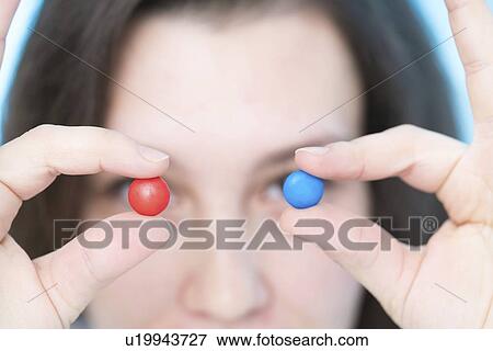 Woman holding pills in front of eyes View Large Photo Image Stock Photo - Woman holding pills in front of eyes. Fotosearch