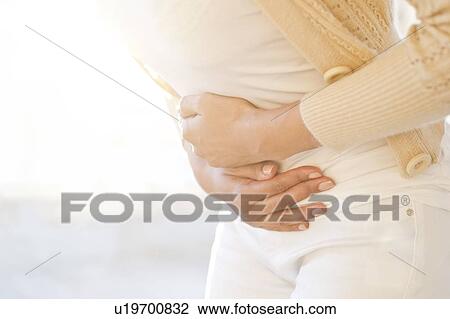 Woman holding stomach in pain. View Large Photo Image Stock Image - Woman holding stomach in pain.. Fotosearch