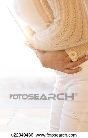 Woman holding stomach in pain. View Large Photo Image Stock Photograph - Woman holding stomach in pain.. Fotosearch