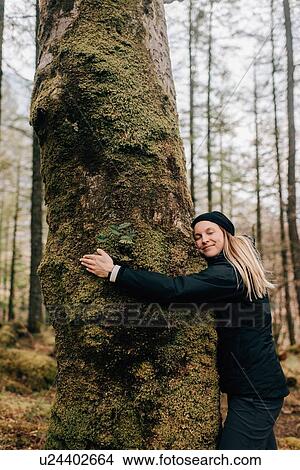 Picture - Woman hugging tree, Trossachs National Park, Canada. Fotosearch