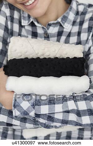 Stock Photo - Woman in checked shirt holding fabrics. Fotosearch