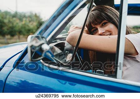 Stock Photography - Woman leaning against steering wheel. Fotosearch