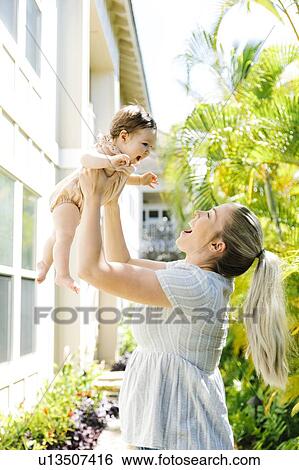 Woman lifting baby daughter View Large Photo Image Stock Photograph - Woman lifting baby daughter. Fotosearch